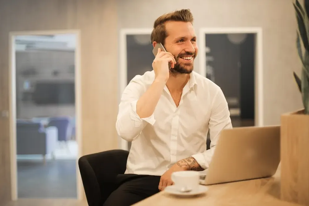 Mann am Telefon mit einem weißen Hemd